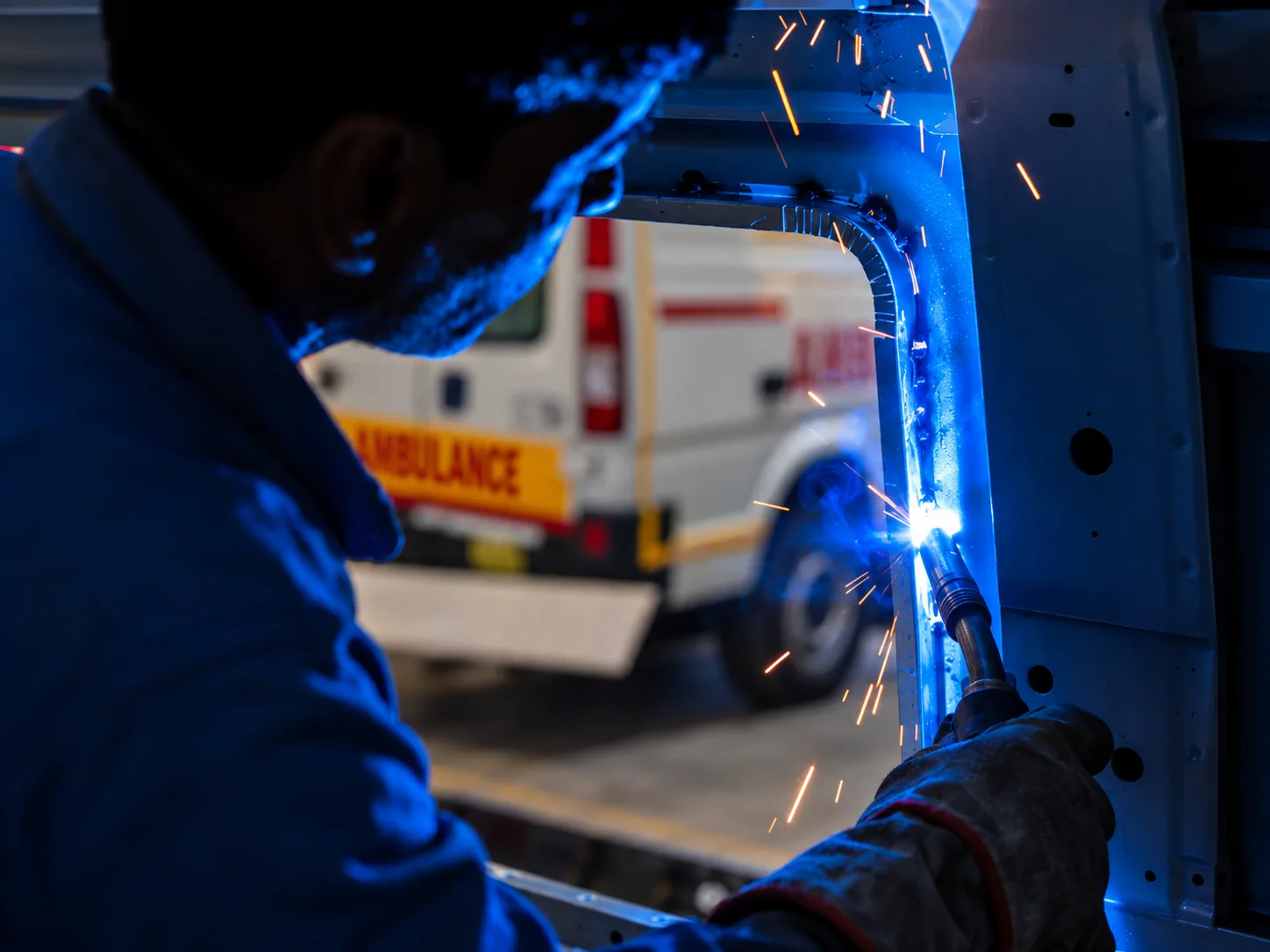 Skilled technician welding an ambulance frame